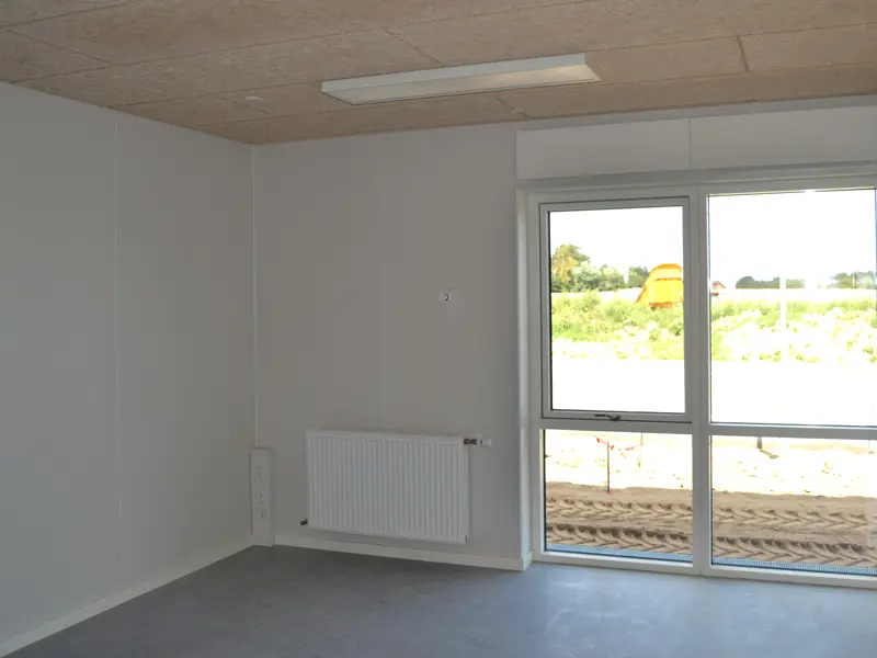 Et rum uden indretning, lenoliumgulv og hvide vægge.