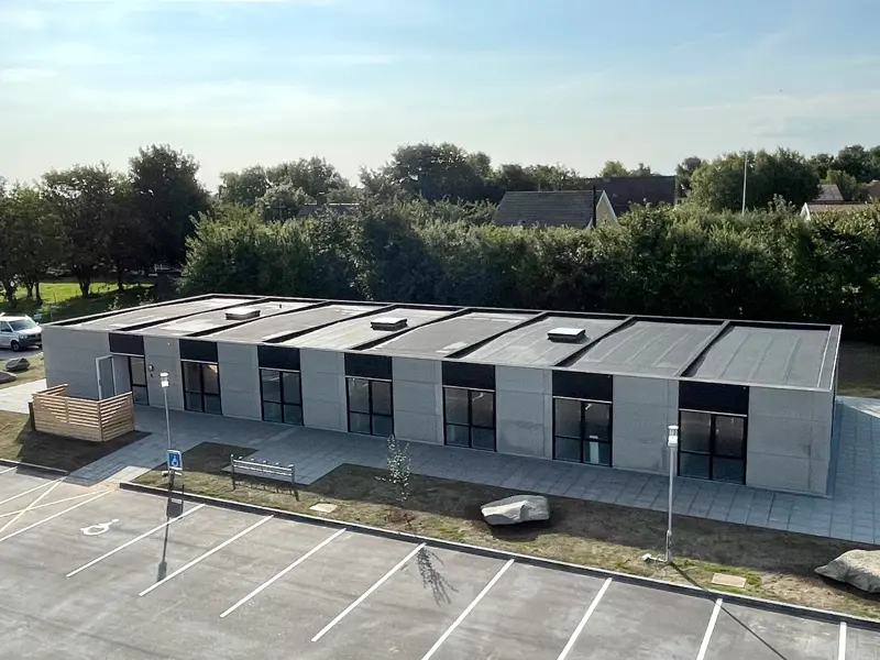 Bygning set fra luften. Bygget i Flexicubes® med grå facader og træbeklædning over vinduer