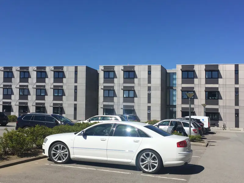 3 kontorbygninger ved siden af hinanden i 3 etager. Biler på parkeringspladsen foran